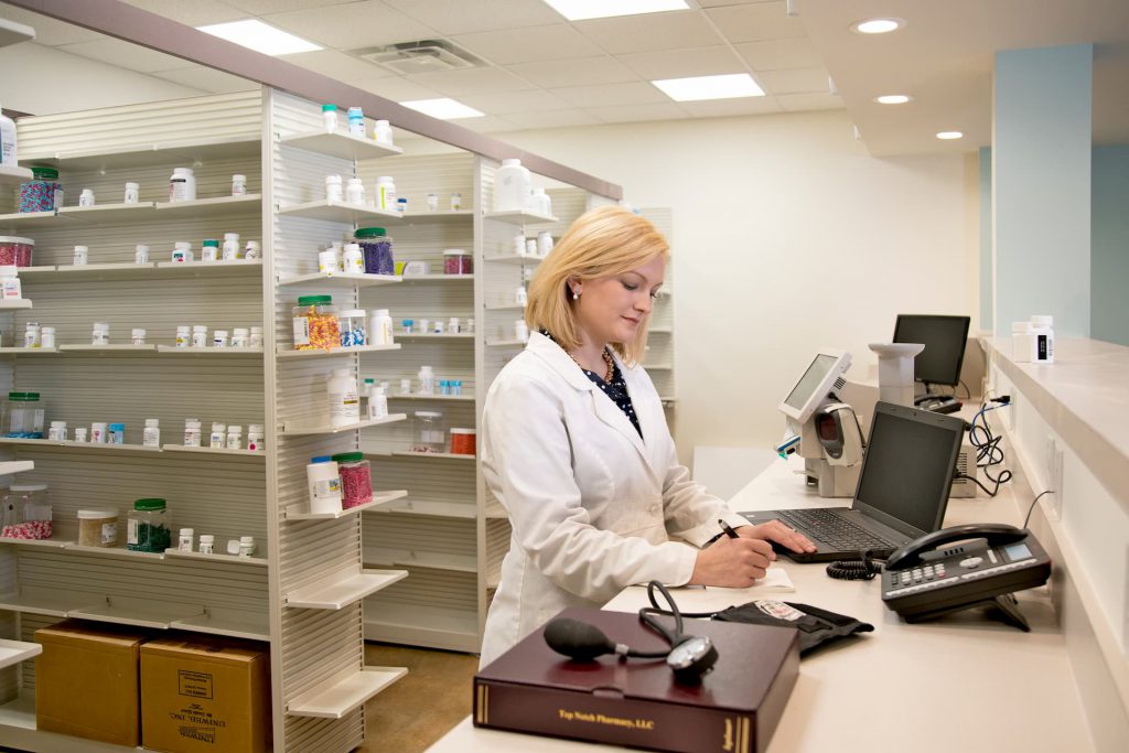 Leah B. Argie working at the pharmacy behind the counter